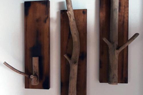 three wooden clocks with branches on a wall at Country House Ca' Vernaccia in Urbino