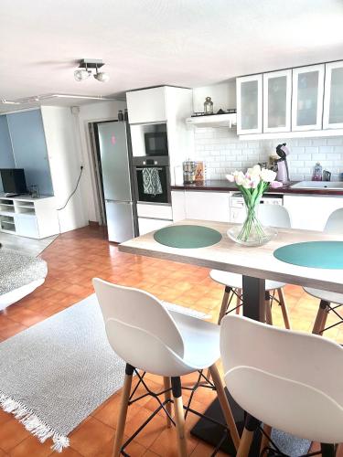 une cuisine et un salon avec une table et des chaises dans l'établissement La Perle, proche Roissy CDG, Paris, Parc asterix, Disney, à Moussy-le-Vieux