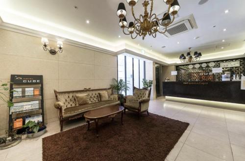 a lobby with a couch and a table and chairs at Hotel Cube in Incheon