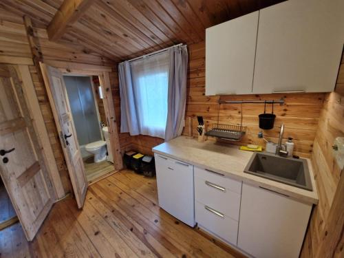 a kitchen in a log cabin with a sink at OKW Bursztyn Międzywodzie in Międzywodzie