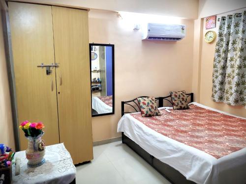 a small bedroom with a bed and a mirror at Varshav Villa in Pune