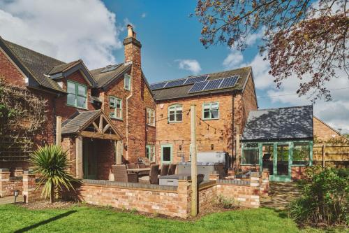 a brick house with solar panels on the roof at Sandy Hill Farm in Curborough