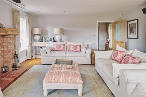 a living room with two white couches and a coffee table at Sandy Hill Farm in Curborough