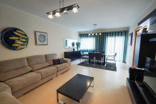 a living room with a couch and a table at Dalila's house - Spacious and Comfortable 3-Bedroom Apartment with Garage in Nazaré