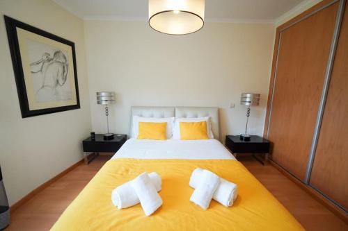 a bedroom with a large bed with two pillows at Dalila's house - Spacious and Comfortable 3-Bedroom Apartment with Garage in Nazaré