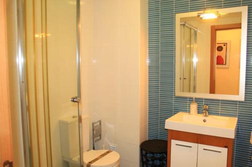ein Badezimmer mit einem WC, einem Waschbecken und einem Spiegel in der Unterkunft Dalila's house in Nazaré