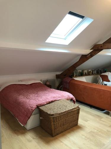 - une chambre mansardée avec un lit et une lucarne dans l'établissement Luminous and cosy loft - close to olympic games, à Saint-Ouen