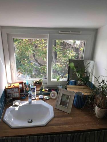 La salle de bains est pourvue d'un lavabo et d'une fenêtre. dans l'établissement Luminous and cosy loft - close to olympic games, à Saint-Ouen