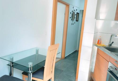 eine kleine Küche mit einem Glastisch und einem Stuhl in der Unterkunft Comfort Studio in City center KM1 in Wien