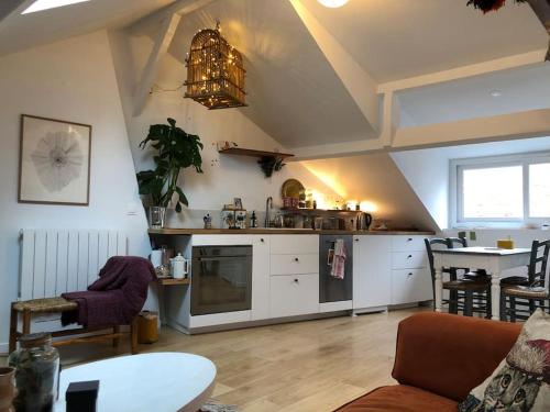 un salon avec une cuisine et une table dans l'établissement Luminous and cosy loft - close to olympic games, à Saint-Ouen