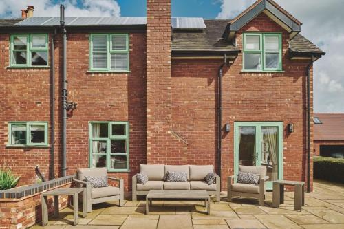 a patio in front of a brick building at Sandy Hill Farm in Curborough