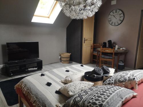 Schlafzimmer mit einem Bett, einem TV und einer Uhr in der Unterkunft Agréable chambre privée avec entrée indépendante in Langeais