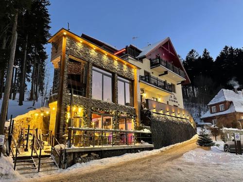 ein Haus mit Licht im Schnee in der Unterkunft Safir przy samym WYCIĄGU in Karpacz