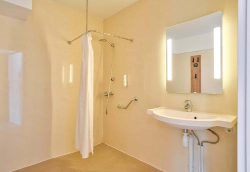 y baño con lavabo y espejo. en B&B HOTEL Paris Malakoff Parc des Expositions, en Malakoff