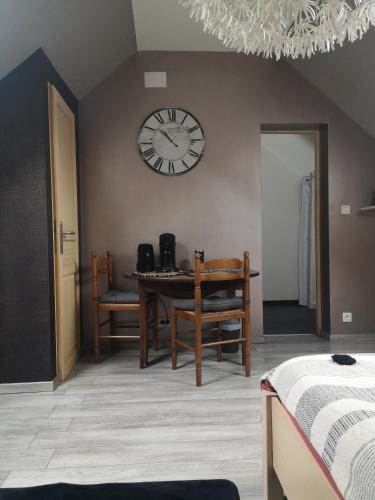 um quarto com uma mesa e um relógio na parede em Agréable chambre privée avec entrée indépendante em Langeais