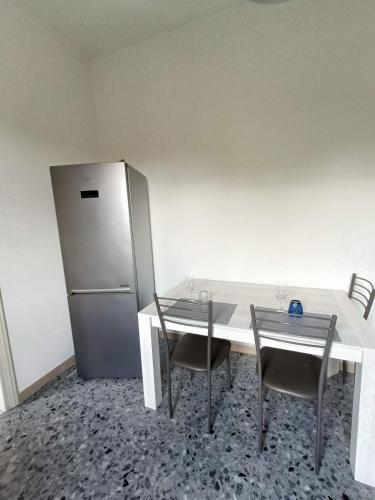 a kitchen with a white table and a refrigerator at A due passi dai Miracoli in Pisa