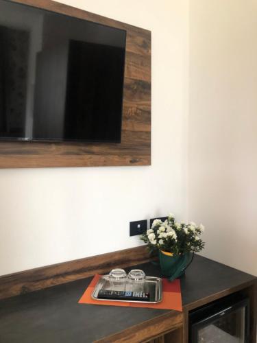 a room with a table with a television and flowers at Villa Regina in Riva del Garda