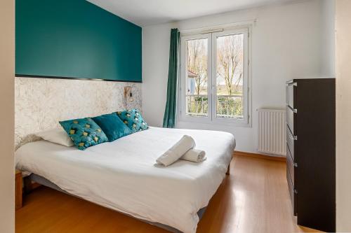 a bedroom with a large white bed with blue pillows at Lake House 4 Bedroomed near Disneyland Paris in Serris