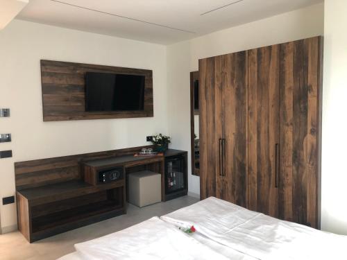 a bedroom with a bed and a tv and a wooden door at Villa Regina in Riva del Garda