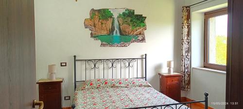 a bedroom with a bed and a picture on the wall at Casavacanze Pergolino, appartamenti ad uso esclusivo in Acquapendente