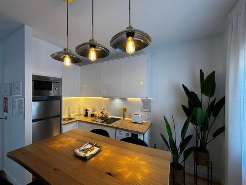 a kitchen with a wooden table and some lights at PIO XII XXl A in Talavera de la Reina