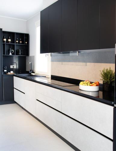 a kitchen with black cabinets and a bowl of fruit on the counter at Jesolo Luxury Suites in Jesolo