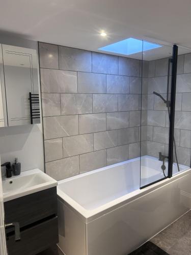 a bathroom with a bath tub and a sink at The Greenhouse in Wick
