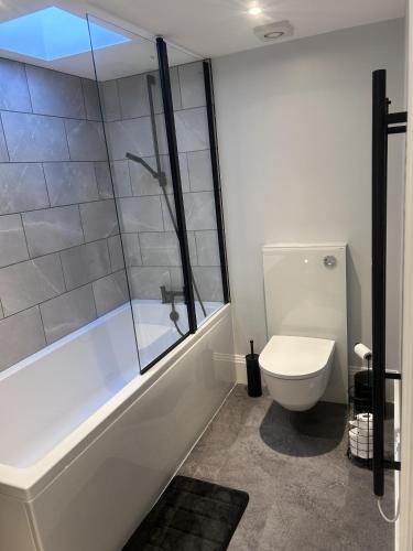 a bathroom with a shower and a toilet and a tub at The Greenhouse in Wick