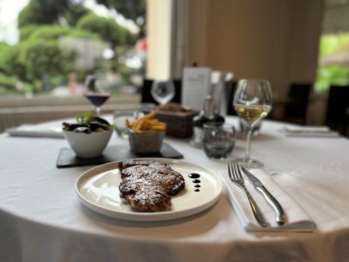 a plate of food on a table with wine glasses at Ambiance Hotel in Limas