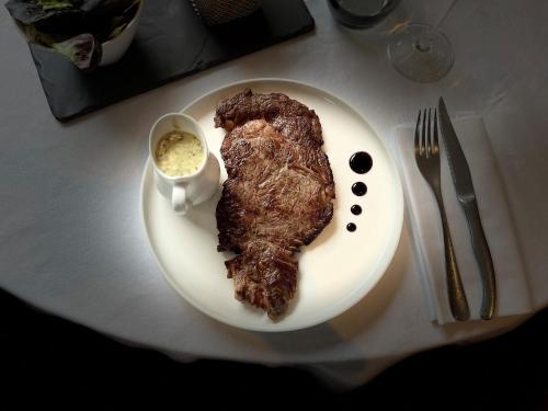 a plate with a piece of meat and sauce on a table at Ambiance Hotel in Limas