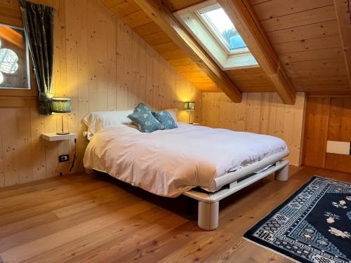 1 dormitorio con 1 cama en una habitación con ventana en Chalet Julie, en Rocca Pietore