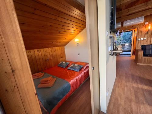 a bed in a room with a wooden ceiling at Apartment Ana with a Charming Jacuzzi near Marija Bistrica in Veliki Komor