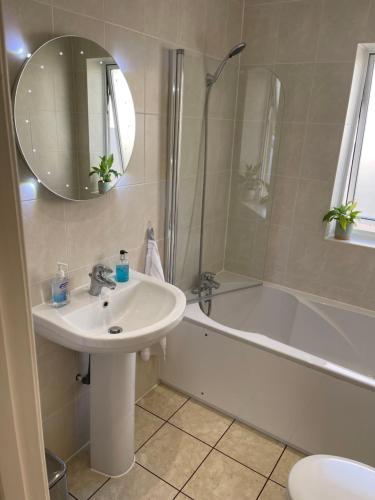 La salle de bains est pourvue d'un lavabo, d'une douche et d'une baignoire. dans l'établissement Home, à Portishead