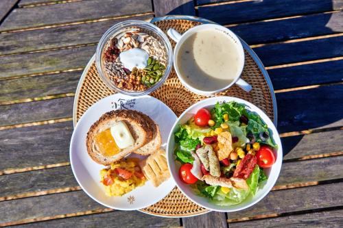 a table with plates of food and a salad and a cup of coffee at Healience Village in Hongcheon