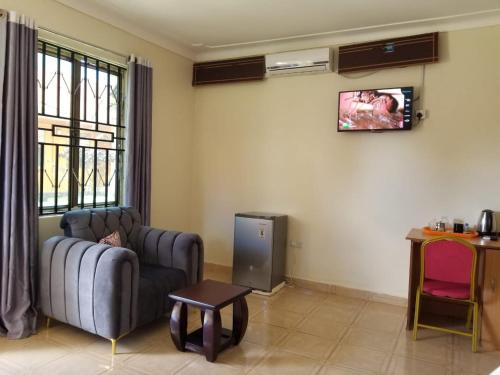 a living room with a couch and a television at Fresh World Hotel in Lira