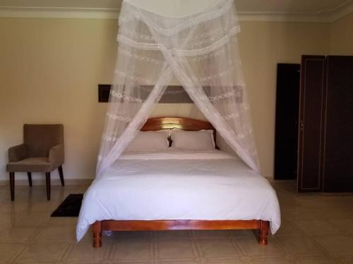 a bedroom with a bed with a mosquito net at Fresh World Hotel in Lira