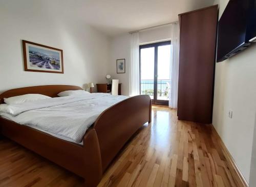 een slaapkamer met een groot bed met een houten vloer bij Apartments SeaView in Portorož