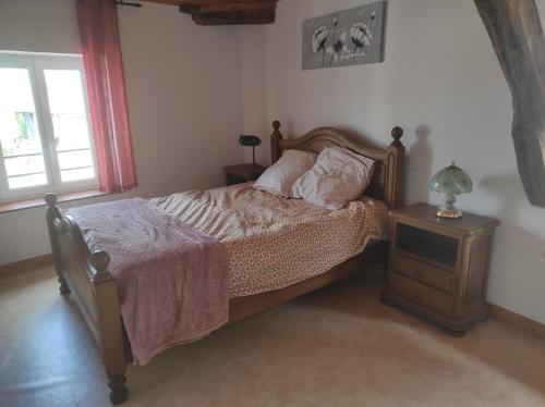 a bedroom with a bed and a table with a lamp at Chez Suzanne Maison à la campagne 2-8pers 4 chambres in Longeville-sur-la-Laines