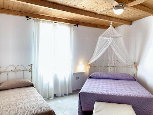 een slaapkamer met 2 bedden en 2 ramen bij 2 bedrooms apartement with terrace at Galtelli in Galtellì