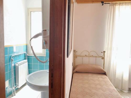 een badkamer met een wastafel en een bed erin bij 2 bedrooms apartement with terrace at Galtelli in Galtellì