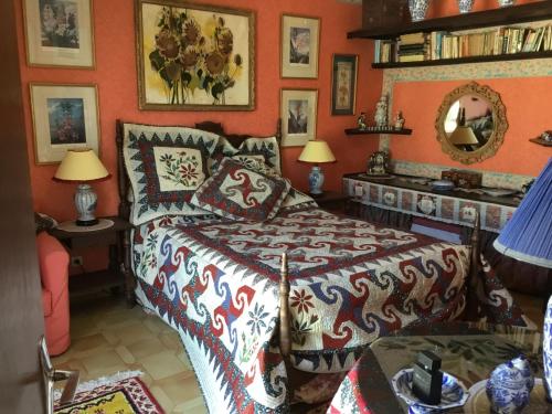 1 dormitorio con 1 cama en una habitación con paredes de color naranja en Villa la Cerisaie., en Reynès