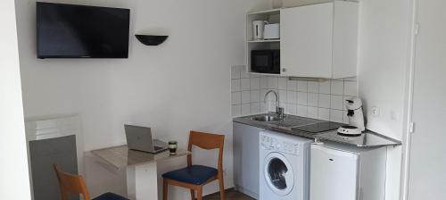 a kitchen with a washing machine and a sink at Cosy Studio La Defense in Courbevoie
