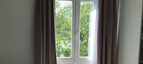 a window in a room looking out at trees at Cosy Studio La Defense in Courbevoie
