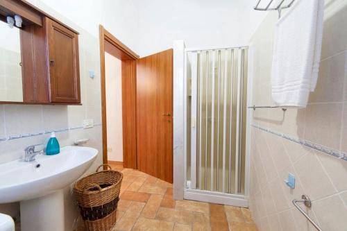La salle de bains est pourvue d'un lavabo, de toilettes et d'une douche. dans l'établissement 2 bedrooms apartement with shared pool furnished terrace and wifi at Rilievo 5 km away from the beach, à Rilievo