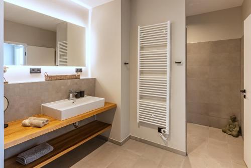 een badkamer met een wastafel en een spiegel bij BLACK PEARL Penthouse Black Pearl in Scharbeutz