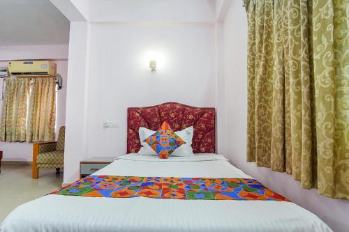 um quarto com uma cama com uma almofada colorida em FabHotel Terra em Chennai