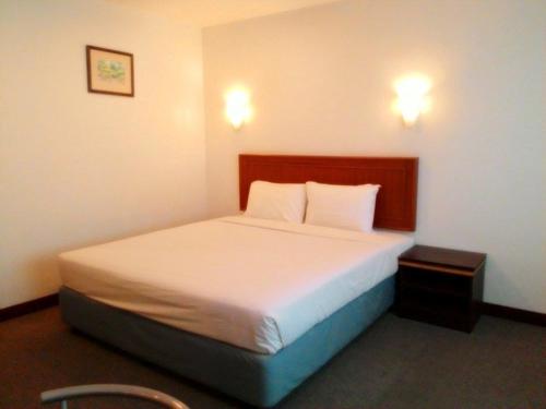 1 dormitorio con 1 cama con 2 luces en la pared en KP hotel en Amphoe Kumphawapi