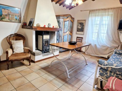 a living room with a table and a fireplace at One bedroom apartement with garden and wifi at Provincia di Siena in Palazzina