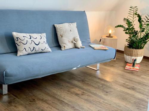 um sofá azul com duas almofadas e um ursinho de peluche em Casa Marcu Wohnung 1 OG em Landkirchen