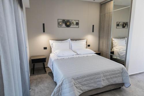 a bedroom with a large bed with white sheets and pillows at Aegeans Eye in Azolimnos